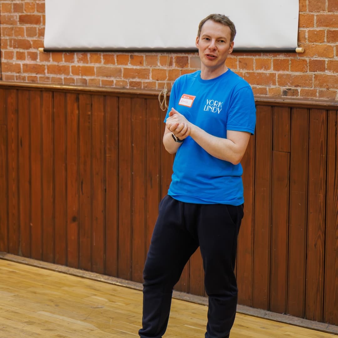 Chris teaching a York Lindy class in a wood-paneled hall